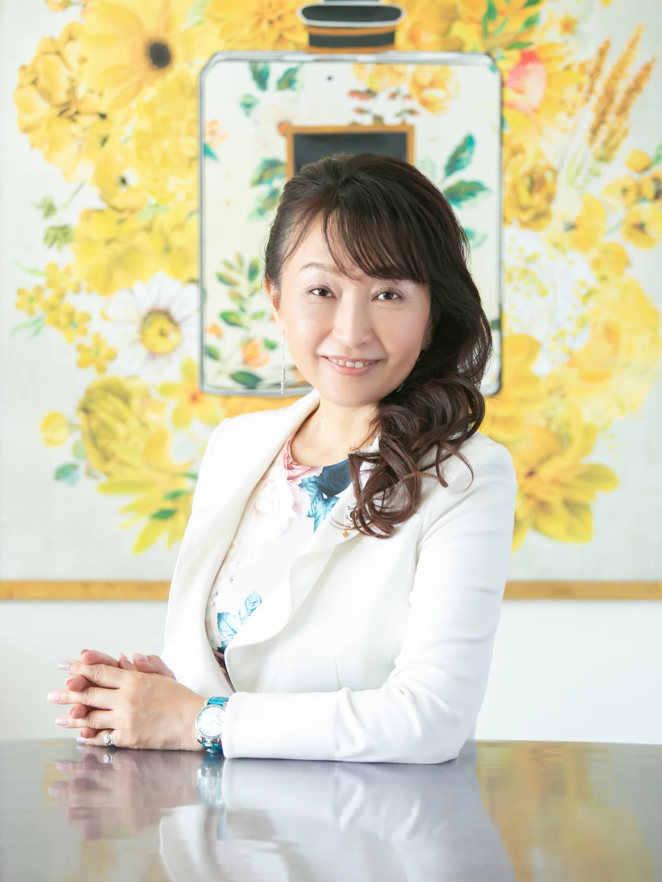黄色い花を背景に白いユニフォームを着た吉永順子
